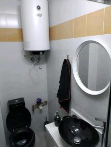 ein Bad mit einem schwarzen WC und einem Waschbecken in der Unterkunft Loft Puente Romano in Salamanca