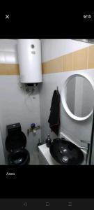 baño con aseo negro y lavamanos en Loft Puente Romano, en Salamanca