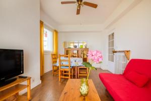 a living room with a red couch and a table at Angelina -fr005 in Cagnes-sur-Mer