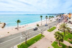 a view of a beach and a road with palm trees at Angelina -fr005 in Cagnes-sur-Mer