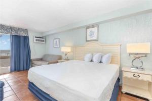 a bedroom with a large bed and a living room at Oceanfront. Ground Floor. Easily Accessible. in Myrtle Beach