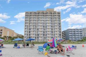 a beach with a large building in the background at Oceanfront. Ground Floor. Easily Accessible. in Myrtle Beach