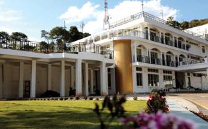 ein großes weißes Gebäude mit Balkon darüber in der Unterkunft La Nicholas Lake View by Summit Hotels in Mawlyngkhung