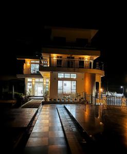 un grande edificio con balcone di notte di La Nicholas Lake View by Summit Hotels a Mawlyngkhung