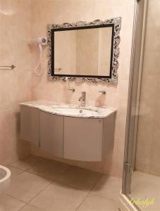 a bathroom with a sink and a mirror on the wall at гостиница Аркалык in Arqalyq