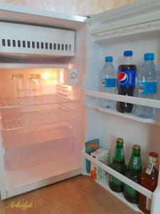 - un réfrigérateur ouvert rempli de bouteilles d'eau et de sodas dans l'établissement гостиница Аркалык, à Arqalyq