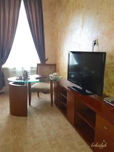a living room with a flat screen tv and a table at гостиница Аркалык in Arqalyq