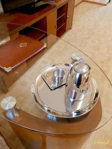 uma mesa de vidro com uma bandeja com uma chaleira de chá em гостиница Аркалык em Arqalyq