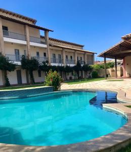 a swimming pool in front of a building at Pousada Praia Do Farol in Alcobaça