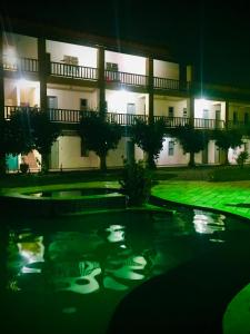 a building with a pool in front of it at night at Pousada Praia Do Farol in Alcobaça