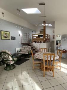 ein Zimmer mit einem Tisch, Stühlen und einer Treppe in der Unterkunft Le Gîte de Jules en Meuse à VIGNOT près de MADINE in Vignot