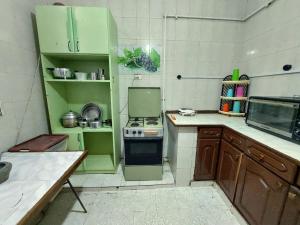 een kleine keuken met groene kasten en een fornuis bij AL- Mazareta a private room at Shared apartment For Men only No Ladies allowed غرفة خاصة في شقة مشتركة للرجال فقط ممنوع السيدات仅限男士 女士不允许 in Alexandrië