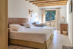 a bedroom with a large bed and a living room at Hotel Es Port in Port de Soller