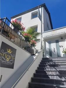 - un bâtiment blanc avec des escaliers et des fleurs dans l'établissement Logement viphouse Valkenburg, à Fauquemont