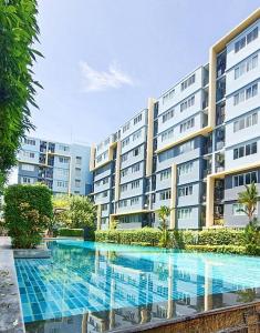 a large building with a swimming pool in front of it at Cozy & Easy living Condo 65/79 in Kathu