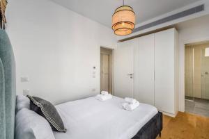 um quarto com uma cama branca e toalhas em Dandy Style from Sea U TLV em Tel Aviv