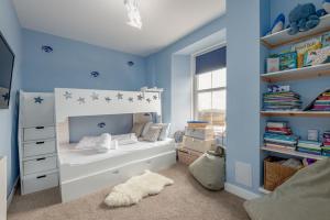 a childs bedroom with a white bed and blue walls at Golf Course View Apartment - Craighead - Crail in Crail