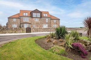 a large brick house on the side of a road at Golf Course View Apartment - Craighead - Crail in Crail