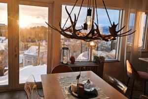 a dining room with a table and a chandelier at Luxury Mountain Apt with Sauna in Narvik