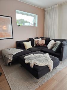 a living room with a black couch and a window at Luxury Mountain Apt with Sauna in Narvik