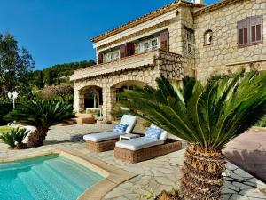 eine Villa mit einem Pool vor einem Haus in der Unterkunft Sea View Villa in the French Riviera in La Colle-sur-Loup