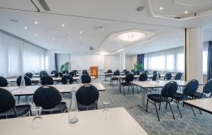 una sala conferenze con tavoli, sedie e un podio di Metropole Swiss Quality Hotel a Interlaken