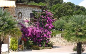 einen Garten mit lila Blumen vor einem Gebäude in der Unterkunft Sea View Villa in the French Riviera in La Colle-sur-Loup