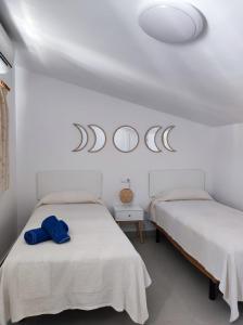 ネルハにあるHACIENDA 36 MENYBERの白い壁の客室内のベッド2台