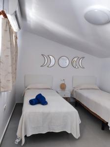 Cette chambre comprend 2 lits et 2 miroirs sur le mur. dans l'établissement HACIENDA 36 MENYBER, à Nerja