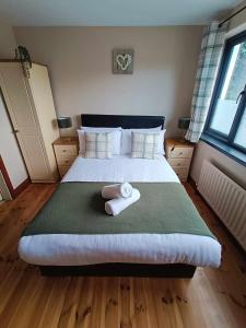 una camera da letto con un grande letto con asciugamani di Dingle Atlantic Lodge B&B a Dingle