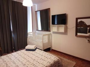 a bedroom with a crib and a tv on the wall at Hostal in Mieres