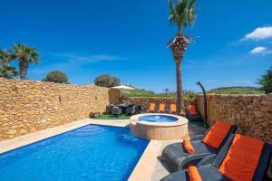 una piscina con sedie e una palma di Levecca 2 Holiday Home a Għasri