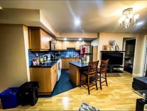 - une cuisine avec des placards en bois, une table et des chaises dans l'établissement Cozy basement,, à Colline De Richmond