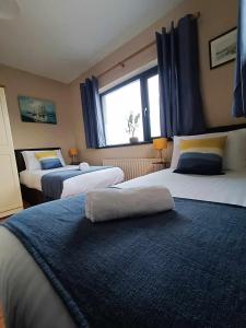 a bedroom with two beds and a window at Dingle Atlantic Lodge B&B in Dingle