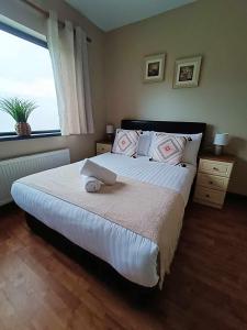 a bedroom with a large bed with a large window at Dingle Atlantic Lodge B&B in Dingle