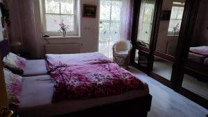 a bedroom with a bed with a purple blanket on it at Ferienhaus Ebert, Top-Ausstattung mit Garten, Terrasse & Wall-Box bei Dinkelsbühl in Dinkelsbühl