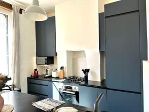 a kitchen with black and white appliances and a table at Appartement Standing dans hypercentre historique in Toulouse