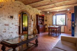 Le Gerlette - La Stalla في Braccagni: غرفة معيشة مع طاولة وغرفة طعام