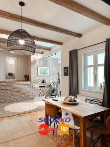 un soggiorno con tavolo e muro di mattoni di Marvellous Cozy Villa in Old Center Town Brasov a Braşov