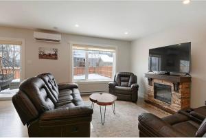 a living room with leather furniture and a fireplace at New Beautiful modern house in Dieppe in Dieppe