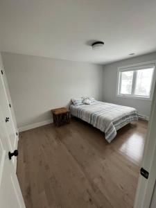 a white bedroom with a bed and a wooden floor at New Beautiful modern house in Dieppe in Dieppe