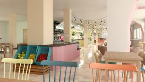 a restaurant with colorful chairs and tables in a room at Hotel Calimera Fido Gardens in Cala d´Or
