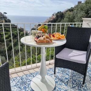 a table with a plate of food on a balcony at Il Canneto in Positano