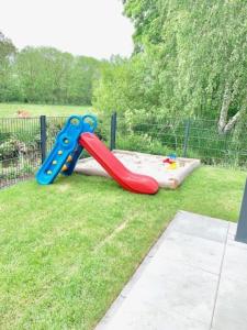 a playground with a slide in the grass at Gemütliches Ferienhaus mit Pool DIREKT am Deich an der Nordsee, Nähe Center Parks in Sehestedt