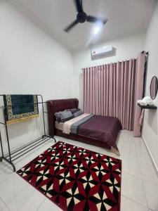 1 dormitorio con cama y alfombra en el suelo en Hazzani Homestay KLIA, en Banting
