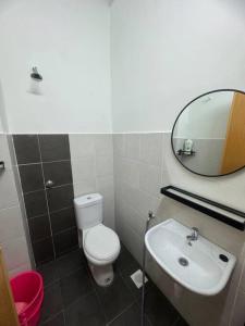 a bathroom with a toilet and a sink and a mirror at Hazzani Homestay KLIA in Banting