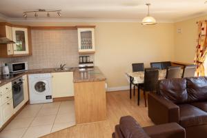 a kitchen and living room with a couch and a table at Knightsbrook Hotel Courtyard Accommodation in Trim