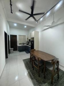 a dining room with a table and a kitchen at Hazzani Homestay KLIA in Banting