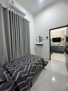 a bedroom with a bed and a window with curtains at Hazzani Homestay KLIA in Banting