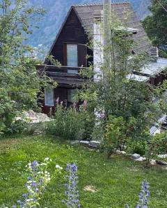 a house with a yard with flowers in front of it at Chalet charme vista panoramica sauna idromassaggio (Chalet Fanella) in Valtournenche